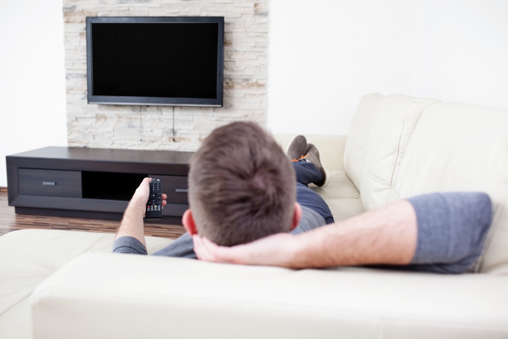 man watching tv on sofa