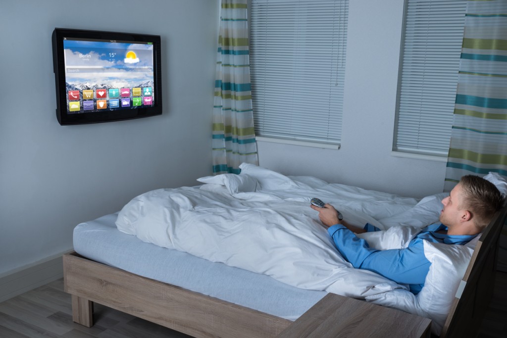 Student in bed watching a smart TV