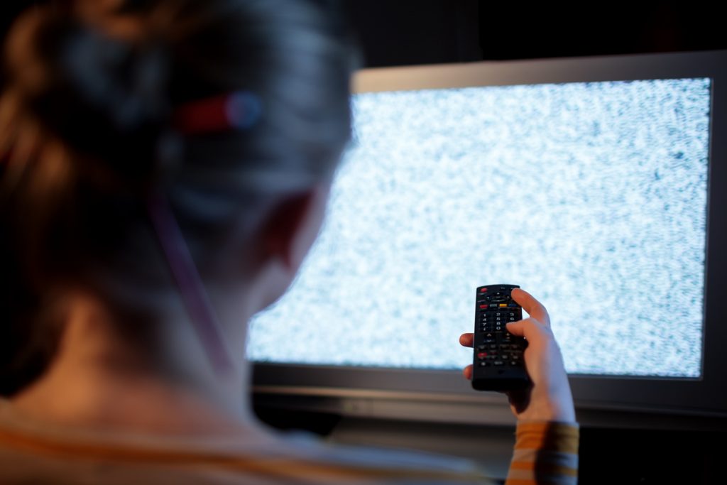 Woman struggling to get signal on her TV