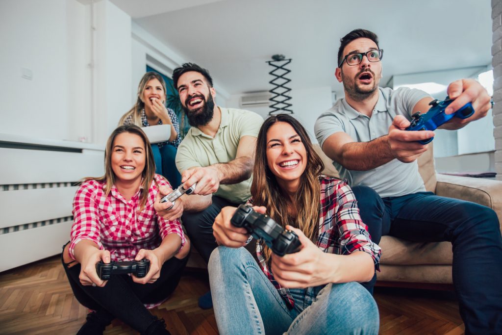 A group of friends using a games console with their TV
