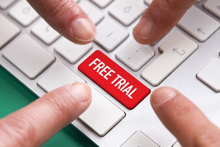 Fingers pointing at a free trial button on a keyboard