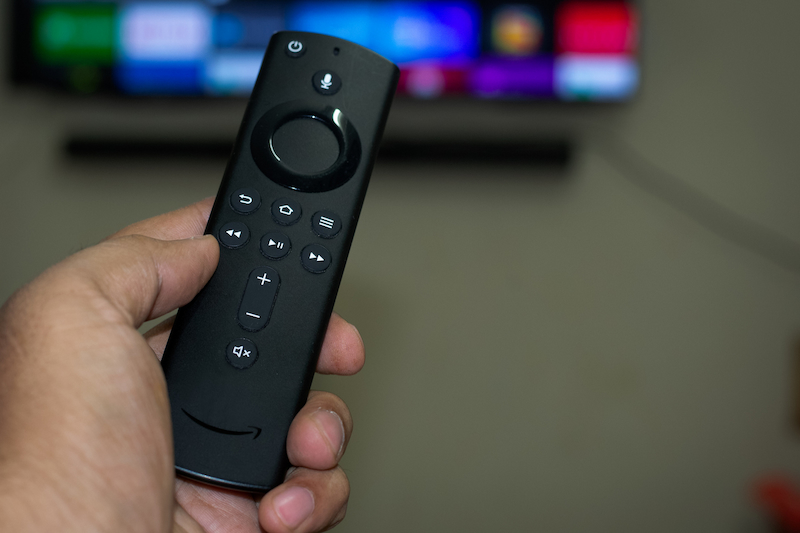 Amazon remote in hand with TV in background