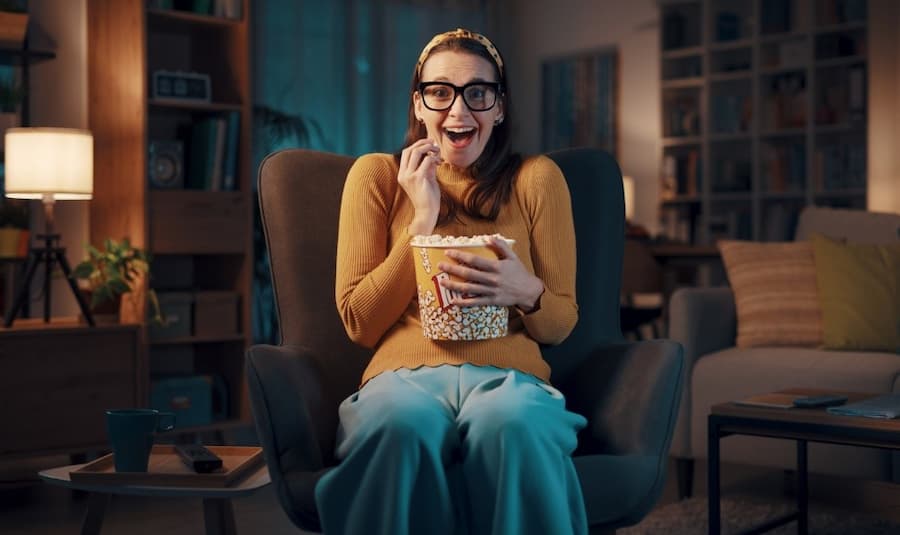 A person sitting in a chair eating popcorn
