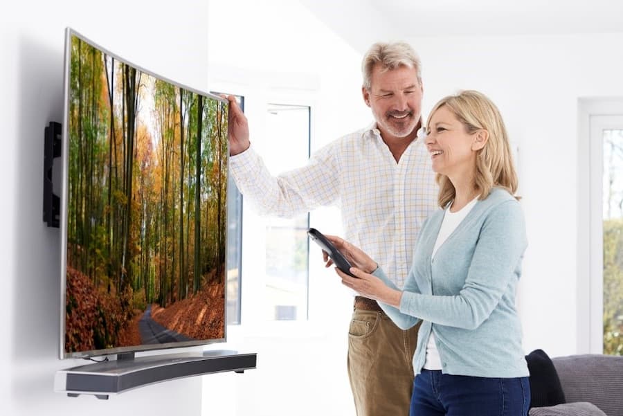 A person and person looking at a curved tv